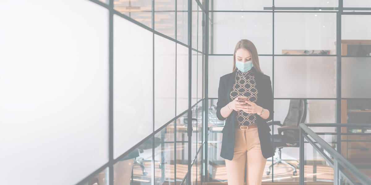 business woman wearing a mask using her phone