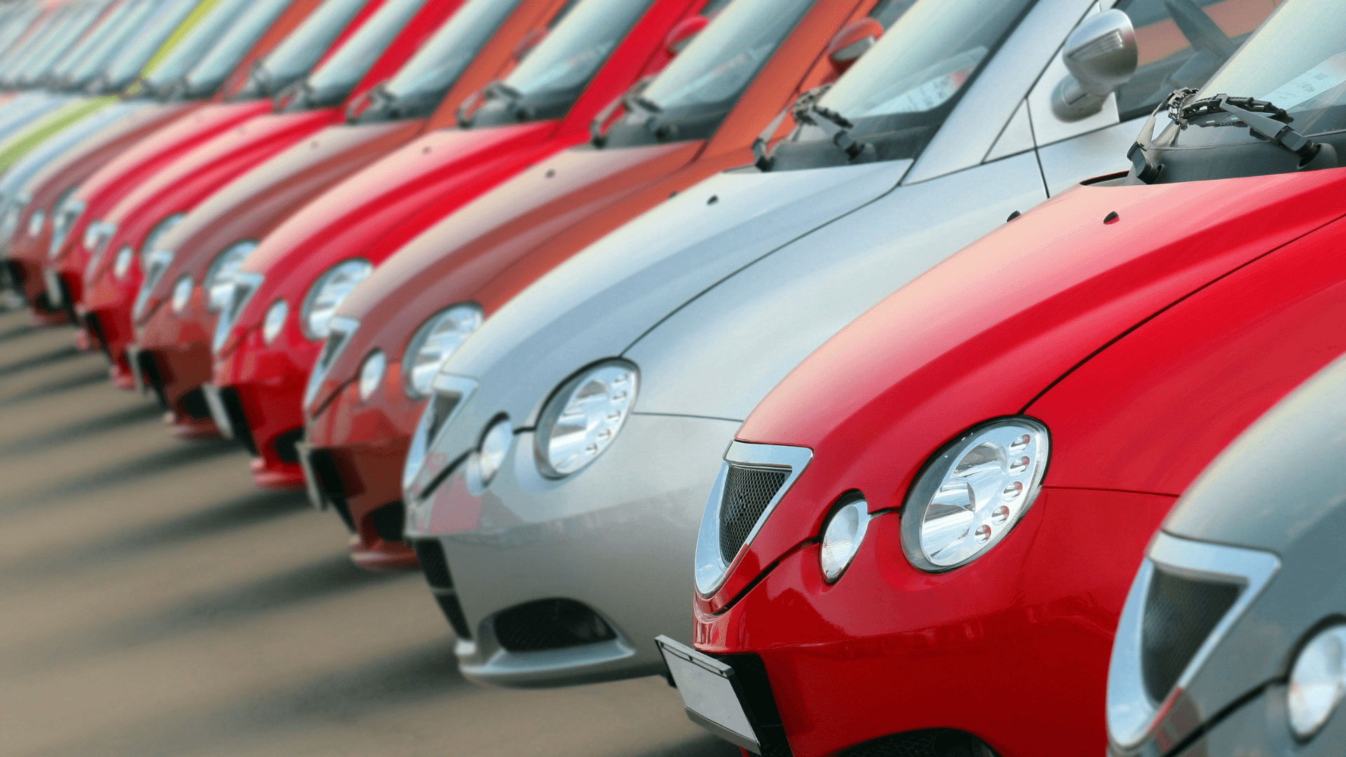 a fleet of red and silver cars lined up next to each other 
