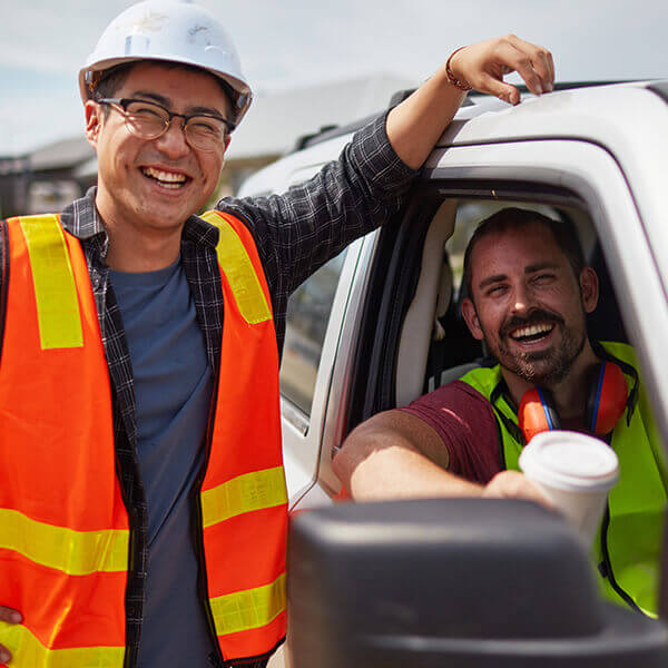 Work colleagues by work vehicle at work site