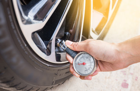 man checking the vehicles tyre pressure 