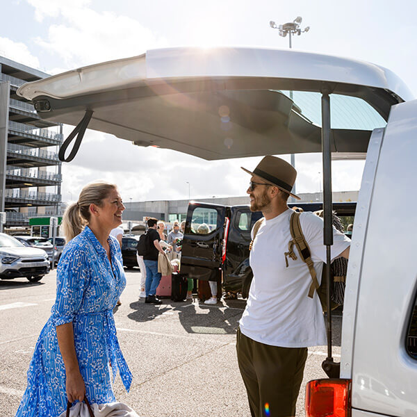 Couple getting in hire car at airport